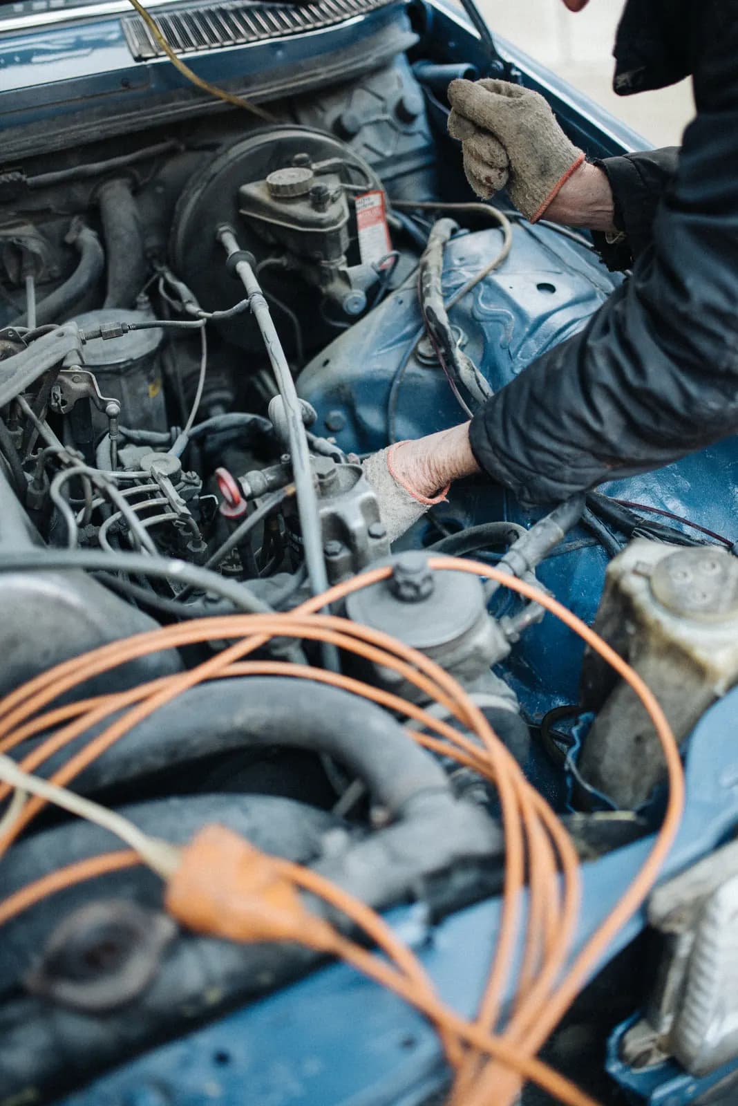 Gloved hands working on an engine bay during a repair